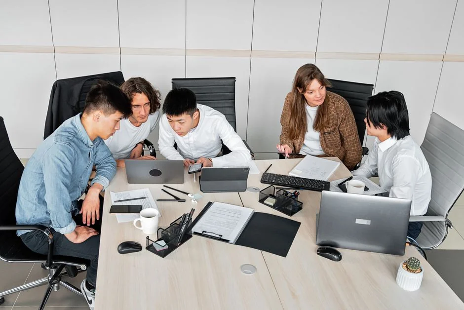 Team reviewing financial charts and digital data on tablets in an office setting.